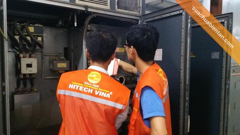 Hai kỹ thuật viên Hitech Vina kiểm tra tủ điện tại nhà máy khách hàng